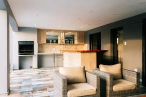 a living room with two chairs and a kitchen at Villa Limonero in Naboomspruit