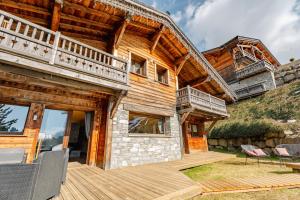a log house with a deck and patio at Chalet Virolet Jacuzzi Hammam Cheminée 15 pers - MultiPass in Les Gets