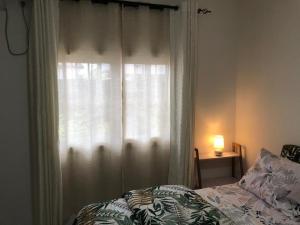 a bedroom with a bed and a window with curtains at Studio 1 chambre in Port-Gentil