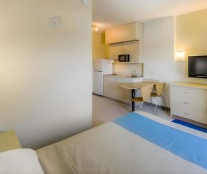 a bedroom with a bed and a desk and a television at Super 8 by Wyndham Estevan in Estevan