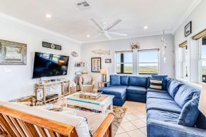 a living room with a blue couch and a tv at Gulf Breezes Unit A in Port Aransas