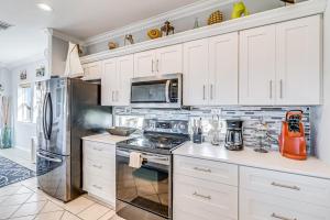 a kitchen with white cabinets and a stove top oven at Gulf Breezes Unit A in Port Aransas