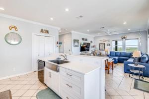a kitchen and living room with a blue couch at Gulf Breezes Unit A in Port Aransas +33 photos