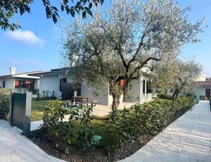 a house with a tree and a picnic table at Bungalow Ville d'Oro in Desenzano del Garda