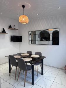 a dining room with a black table and chairs at Maria’ s apartment in Lavrio