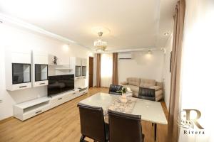 a living room with a dining table and a couch at Apartments Rivera in Dobrich