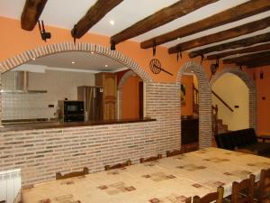 uma sala de jantar com uma mesa e uma parede de tijolos em Aititerena em Murueta-Orozko