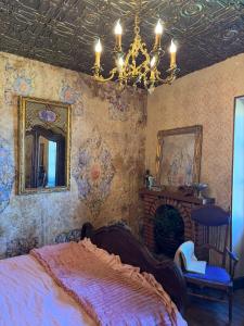 a bedroom with a bed and a mirror and a chandelier at Charming BB Room in Historic Saint-Martial-le-Mont, Creuse in Saint-Martial-le-Mont