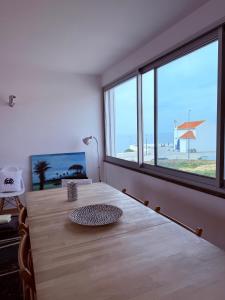a room with a table with a view of the beach at Sunset Beach House in Zambujeira do Mar