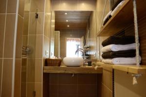 a bathroom with a sink and a mirror and towels at Sorte do Jugo - Lakeside cottage with private beach in Vieira do Minho +26 photos