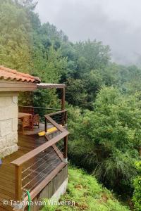 a porch of a house with a view of a forest at Sorte do Jugo - Lakeside cottage with private beach in Vieira do Minho