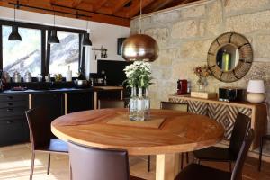 a dining room with a wooden table and a stone wall at Sorte do Jugo - Lakeside cottage with private beach in Vieira do Minho