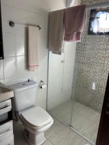 a bathroom with a toilet and a shower at Pedra Branca Retreat in Garopaba +6 photos