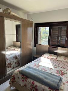 a bedroom with two beds and a mirror at Pedra Branca Retreat in Garopaba