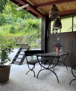 a patio with a table and chairs on a porch at Zielony Pokój in Ojców