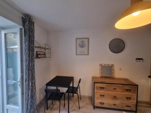 a dining room with a table and a dresser at Studio pour 2 en plein centre-ville in Dol-de-Bretagne