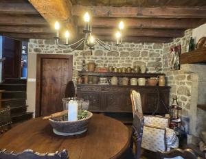 a dining room with a wooden table and a chandelier at Charming 19th-Century BB in Saint-Martial-le-Mont, Creuse in Saint-Martial-le-Mont