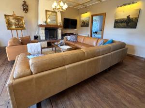 a large brown couch in a living room at Charming 19th-Century BB in Saint-Martial-le-Mont, Creuse in Saint-Martial-le-Mont