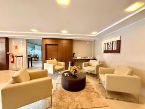 a living room with couches chairs and a table at Alfa Plaza Hotel in Brasília
