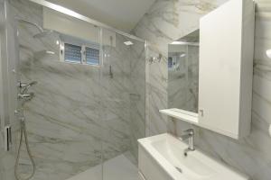 a white bathroom with a shower and a sink at Casa Estação Douro Vista in Vila Marim +13 photos