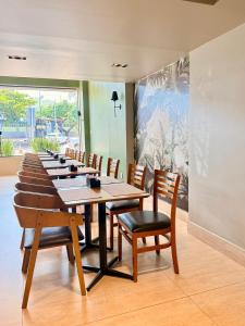 a row of tables and chairs in a restaurant at Alfa Plaza Hotel in Brasília +37 photos