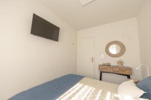 a bedroom with a bed and a flat screen tv at Casa Estação Douro Vista in Vila Marim
