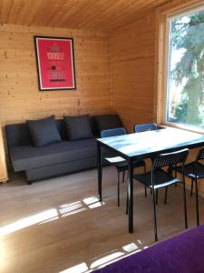 a room with a couch and a table and chairs at Domki Skowronki in Kąty Rybackie