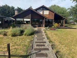 a house with a stone walkway in front of it at Lodge Ruta 71 in Trevelín