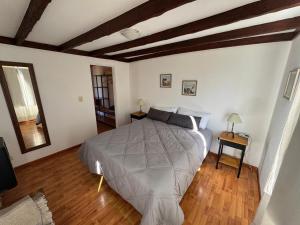 a bedroom with a large bed and wooden floors at Lodge Ruta 71 in Trevelín +8 photos