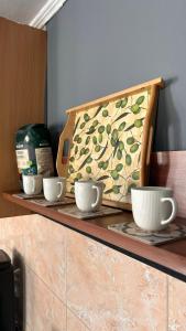 a counter with three cups and a bag on it at Apartman Stone Garden 2 in Mostar