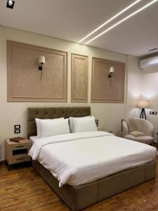 a bedroom with a large white bed and a chair at New LH Cairo Hotel in Cairo