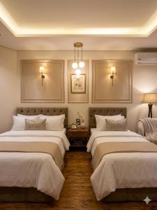 two beds in a room with two lamps at New LH Cairo Hotel in Cairo +3 photos