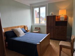 a bedroom with a bed and a window and a dresser at TOUCY Vintage in Toucy