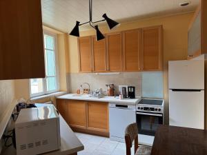 a kitchen with white appliances and wooden cabinets at TOUCY Vintage in Toucy