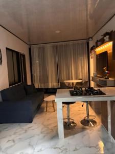 a living room with a couch and a table with a stove at Aparta Hotel La Osadía in Acacías