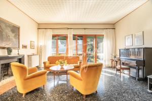a living room with yellow chairs and a piano at Villa Elena in Portovenere