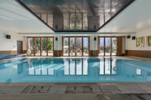 a large swimming pool with blue water in a building at 9 Bed in Alkham oc-m34784 in Swingfield