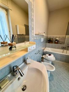 a bathroom with a sink and a toilet and a mirror at Suite Altura in Cuneo