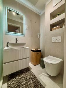 a bathroom with a sink and a toilet and a mirror at HelloWine Apartman II in Eger +16 photos