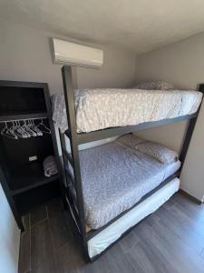 two bunk beds in a room with a television at Casa Conchalito in La Paz