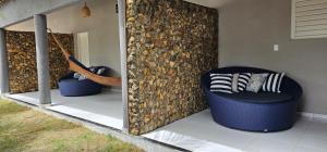 a patio with two chairs and a rock wall at Pousada Du Porto in Macau