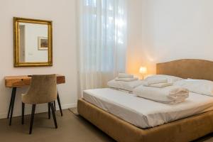 a bedroom with a bed with a mirror and a desk at Luksuzni apartmaji v centru Portoroža z vrtom in parkiriščem - Luxury Apartments in Portoroz Center with Garden & Parking in Portorož