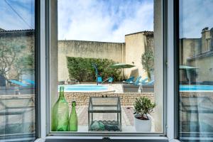 an open window with a view of a pool at Logis Hôtel La Bastide d'Entraigues in Entraigues-sur-la-Sorgue