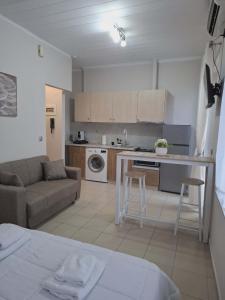 a kitchen and living room with a couch and a table at Studio Panos 2 in Mytilene