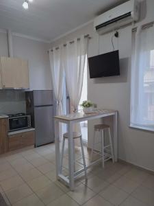 a kitchen with a table and two bar stools at Studio Panos 2 in Mytilene +11 photos