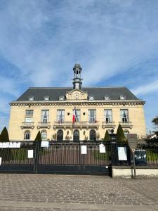 a large building with a clock tower on top of it at T2 cosy & calme - Gare à 1 min accès direct Paris & CDG in Aulnay-sous-Bois