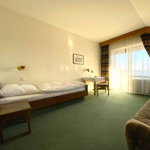 una camera da letto con un letto, una scrivania e una finestra di Hotel Krieger Regensburg a Pettendorf