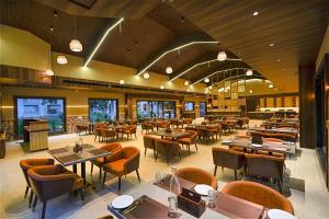 a restaurant with tables and chairs in a room at Vanasya Retreat Corbett in Amgarhi