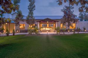a large house with a lawn in front of it at Vanasya Retreat Corbett in Amgarhi