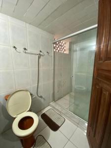 a bathroom with a toilet and a glass shower at Pé na Villa in Itacaré +12 photos